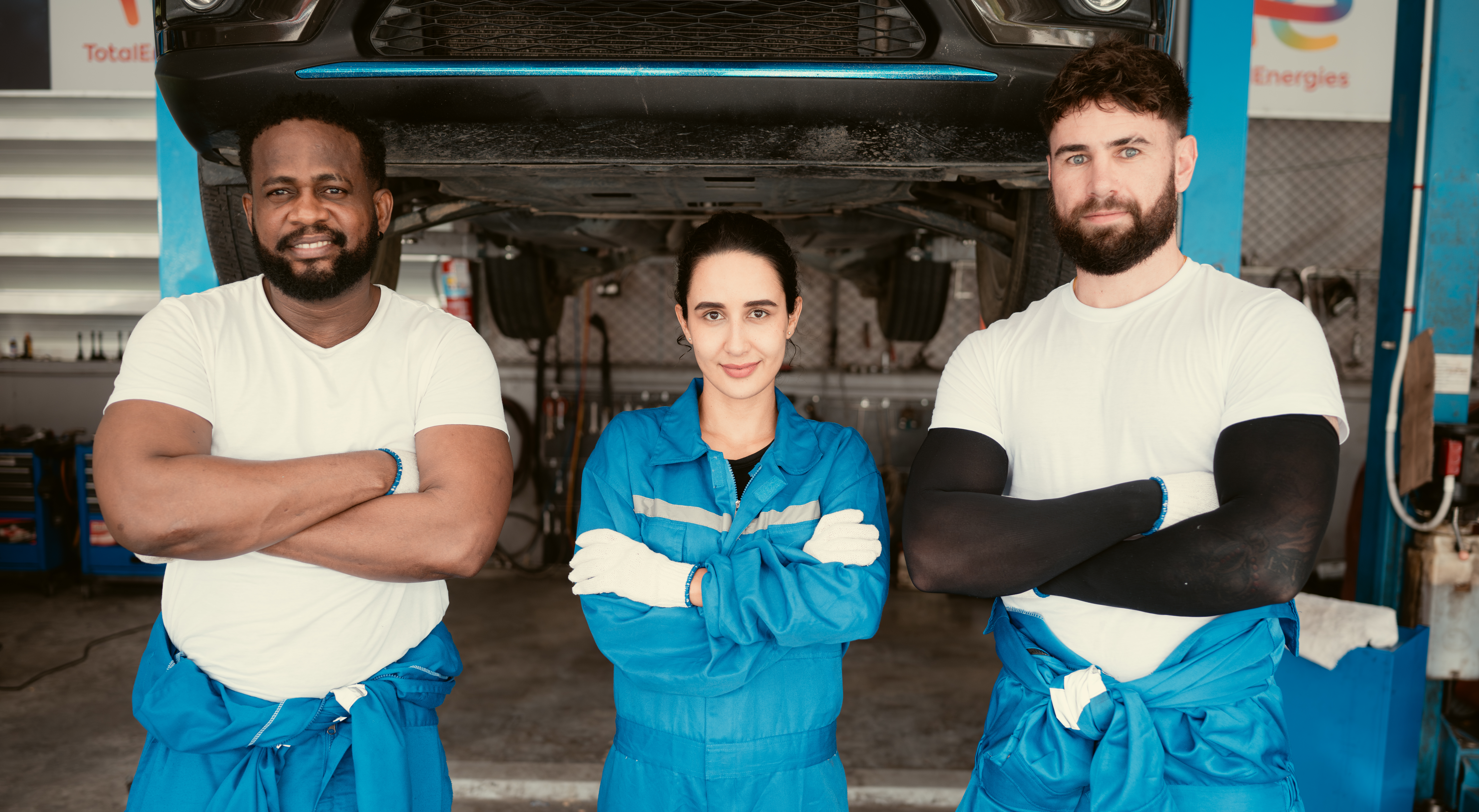 Smiling mechanics standing in Lopez Auto Service repair bay